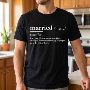 Person wearing a black tee in a kitchen, printed with a white dictionary entry for the word married, its phonetic spelling, and a definition about having someone to say I told you so