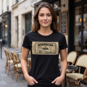 Woman wearing a black tee on a Paris cafe terrace, printed with a large aged cream metro ticket reading Metropolitain de Paris 1ere Classe, the Eiffel Tower faint in the background